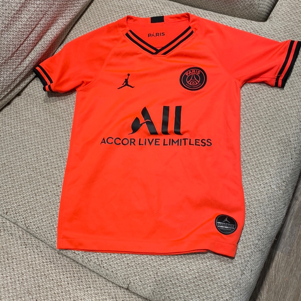 This is a Boys PSG jersey in a size small.